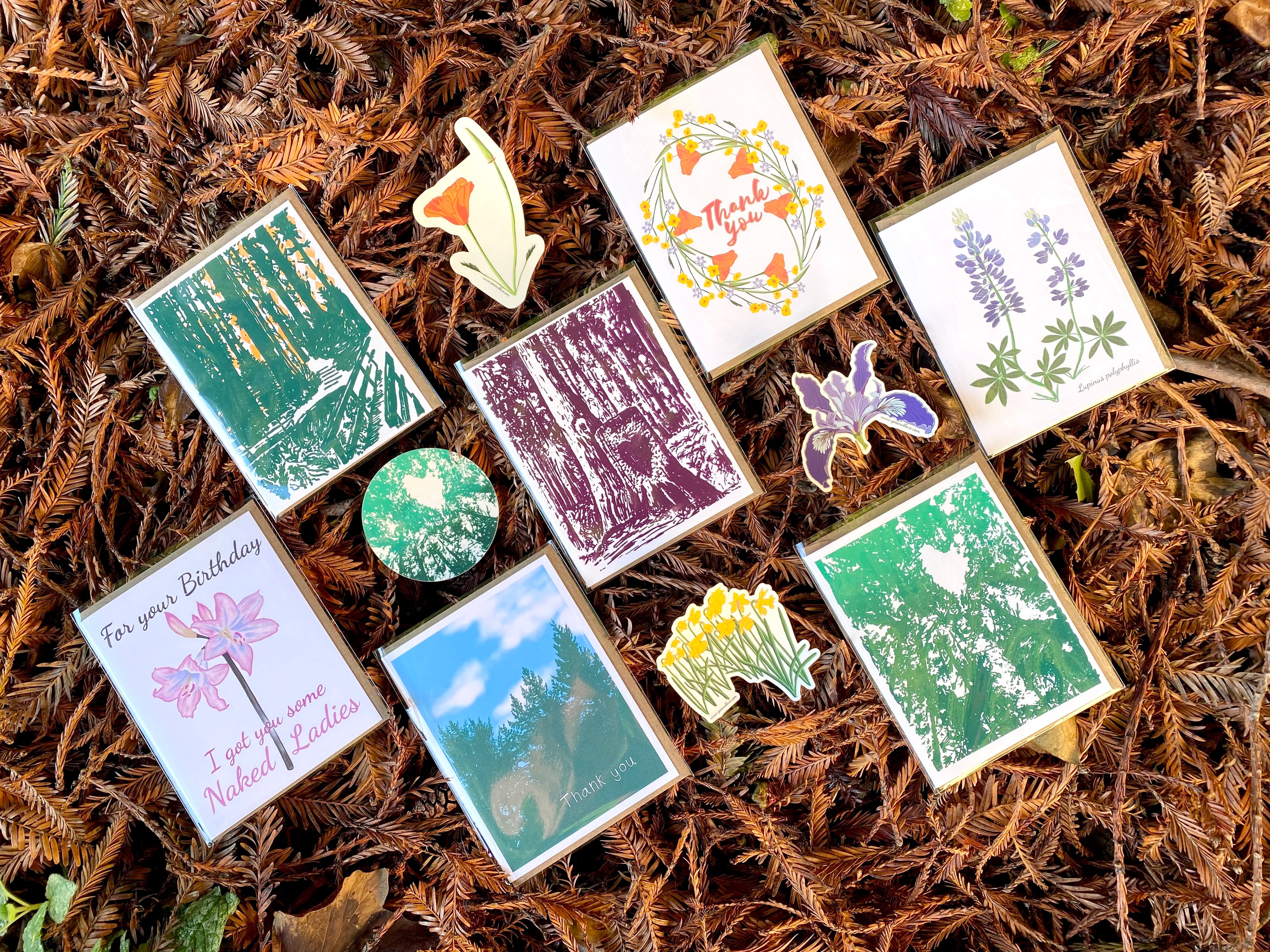 Collection of nature-themed cards and stickers on a textured brown surface